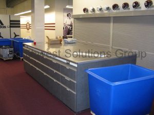 Stainless steel casework serves as infection prevention workspace counter tops for storing and cleaning sports gear.