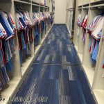 Baseball equipment room storing hanging jerseys