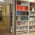 Compact push button bookstack shelving