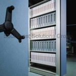 Mechanical assist high density storage binder shelving