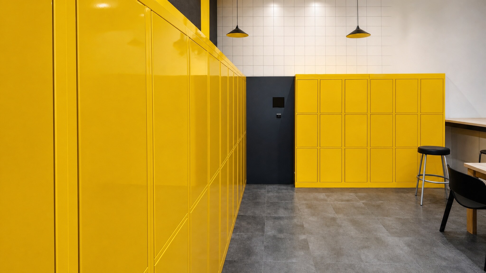 Yellow smart parcel lockers in retail store pickup area with stools
